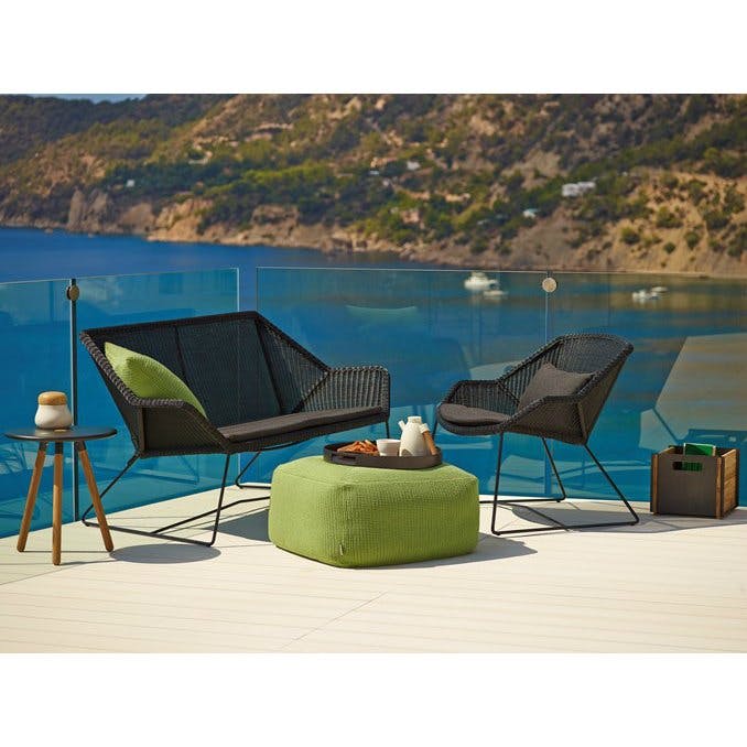 Loungesofa und Loungesessel "Breeze" von Cane-line, Gestell Stahl schwarz, Sitzfläche Polyrattan schwarz und Gartenhocker "Divine" in grün