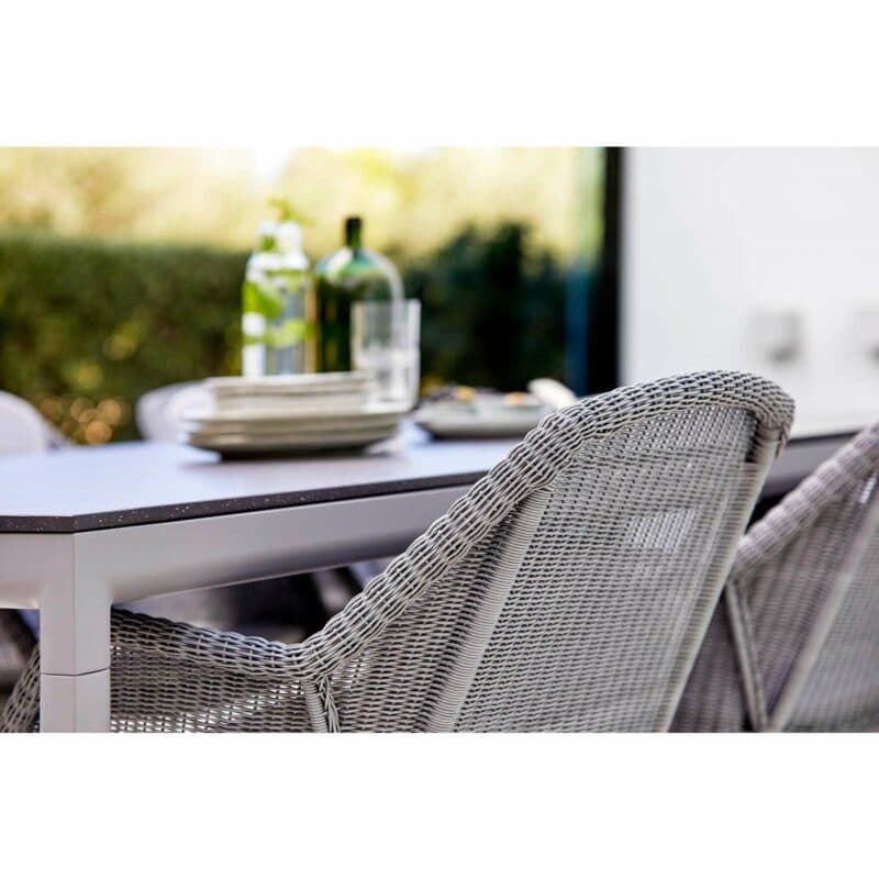 Cane-line "Breeze" Stapelstuhl, Geflecht hellgrau und "Drop" Gartentisch, Alu hellgrau, Keramikplatte schwarz