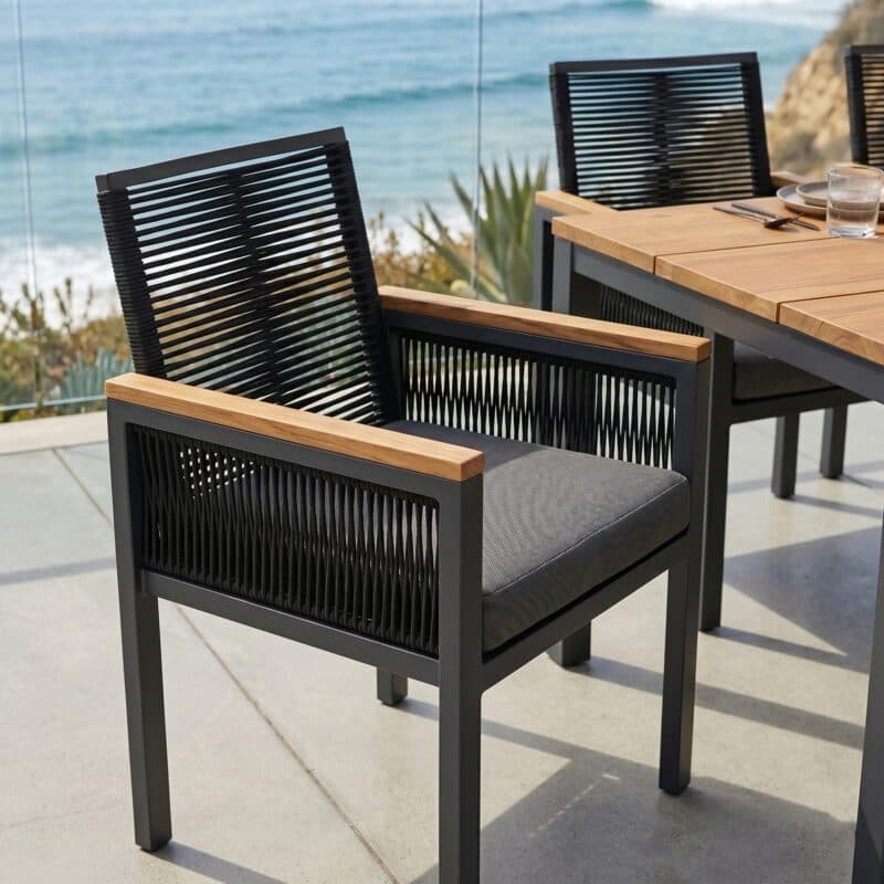 Jati&Kebon "Siara" Gartenstuhl, Gestell Aluminium anthrazit, Rope black, Armlehnen Teak, Kissen grau mit CASA DOMA "Varano" Gartentisch, Gestell Edelstahl anthrazit, Teakplatte, 160x90 cm (Bild KI-generiert)