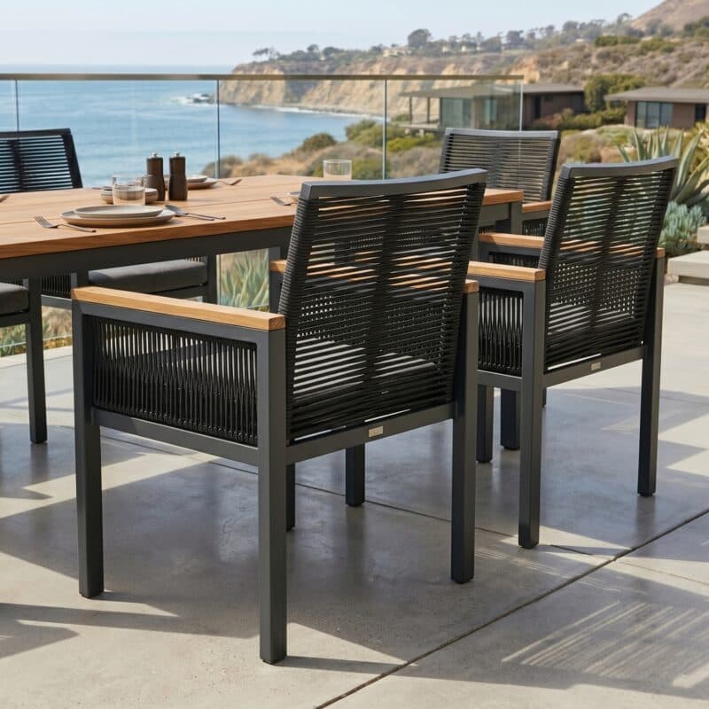 Jati&Kebon "Siara" Gartenstuhl, Gestell Aluminium anthrazit, Rope black, Armlehnen Teak, Kissen grau mit CASA DOMA "Varano" Gartentisch, Gestell Edelstahl anthrazit, Teakplatte, 160x90 cm (Bild KI-generiert)