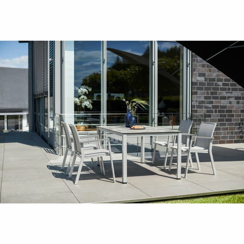 Kettler "Rasmus" Stapelsessel, Gestell Aluminium silber, Armlehne graphit, Polster Textilene® hellgrau Kettler "Rasmus" Stapelsessel, Gestell Aluminium anthrazit, Polster Sunbrella® sooty, Armlehne graphit und Gartentisch "Cubic", Gestell Aluminium silber mit HPL-Platte