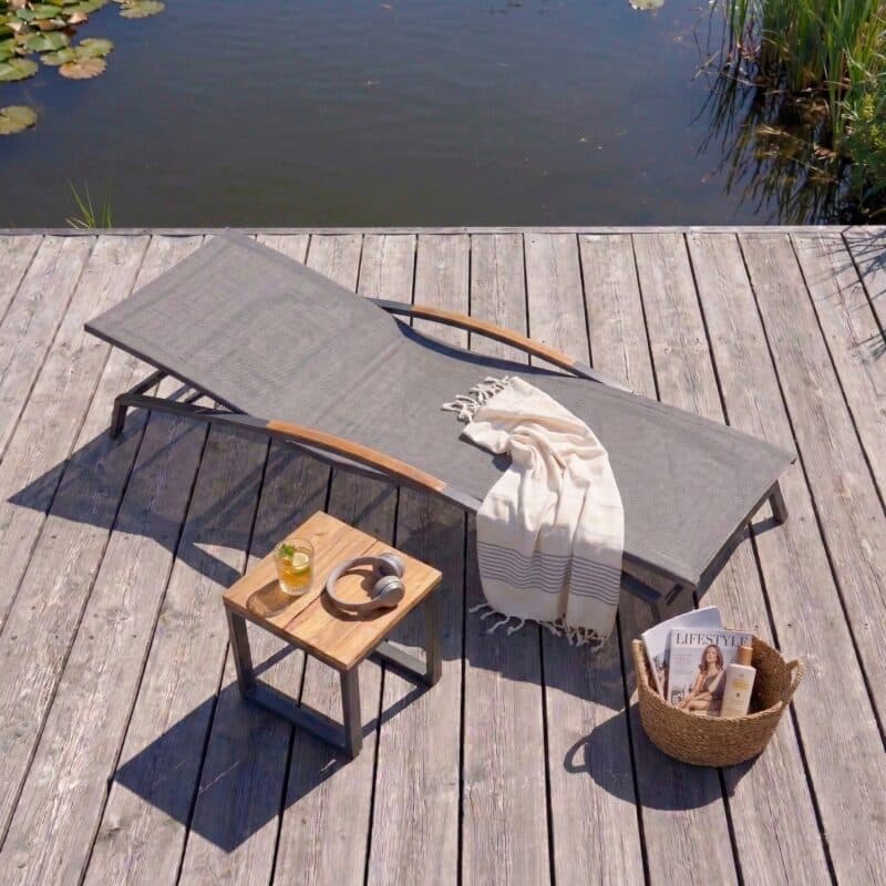 CASA DOMA “Mineo/Macari“ Set 2-teilig mit Sonnenliege Edelstahl anthrazit, Sunproof® Sling schwarz/silber, Armlehnen Teak, Beistelltisch Alu/Teak (Bild KI-generiert)