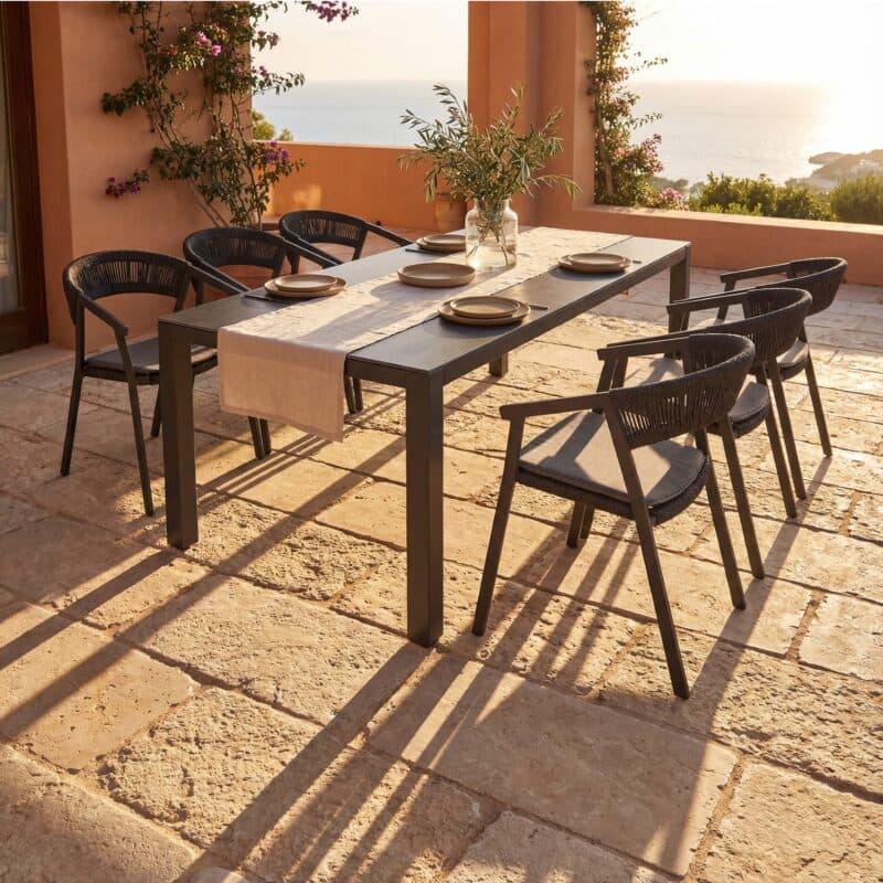 Liadomo Set mit "Lenzi" Stapelstuhl, Aluminium anthrazit, Rope anthrazit, Sitzkissen hellgrau und "Scalea" Tisch, Aluminium anthrazit, Keramikplatte in Granitoptik, 210×100 cm (Bild KI-generiert)