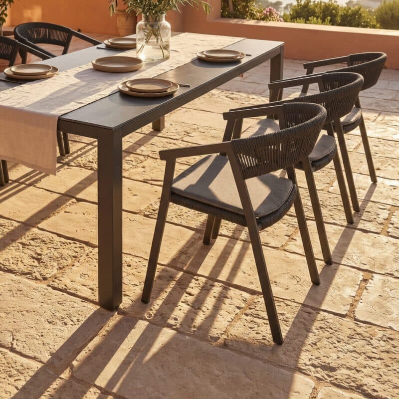 Liadomo Set mit "Lenzi" Stapelstuhl, Aluminium anthrazit, Rope anthrazit, Sitzkissen hellgrau und "Scalea" Tisch, Aluminium anthrazit, Keramikplatte in Granitoptik, 210×100 cm (Bild KI-generiert)