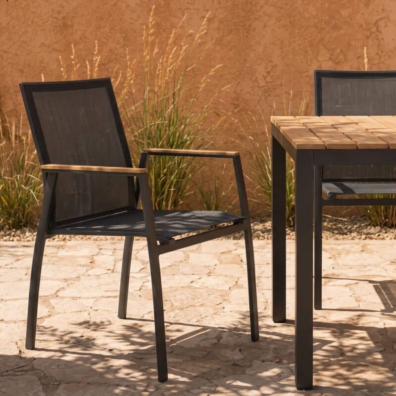 Liadomo Set mit "Scalea" Tisch 160x90 cm, Alu anthrazit, Tischplatte Teak und "Pellaro" Stapelstuhl, Alu anthrazit, Textilgewebe anthrazit, Armlehnen Teak (Bild KI-generiert)