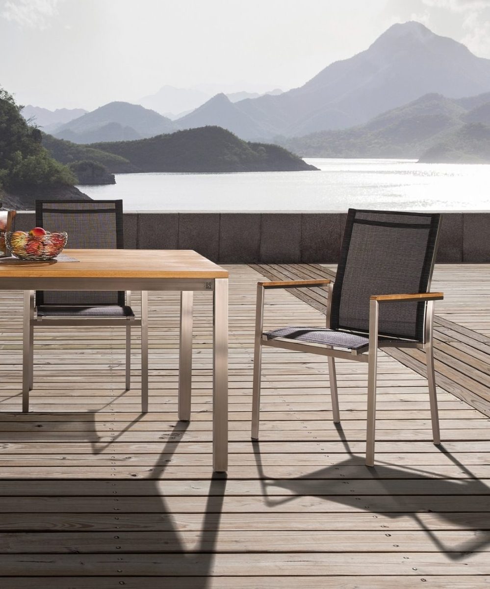 Gartenstuhl und Teaktisch vor majestätischer Kulisse mit Blick auf See und Berge