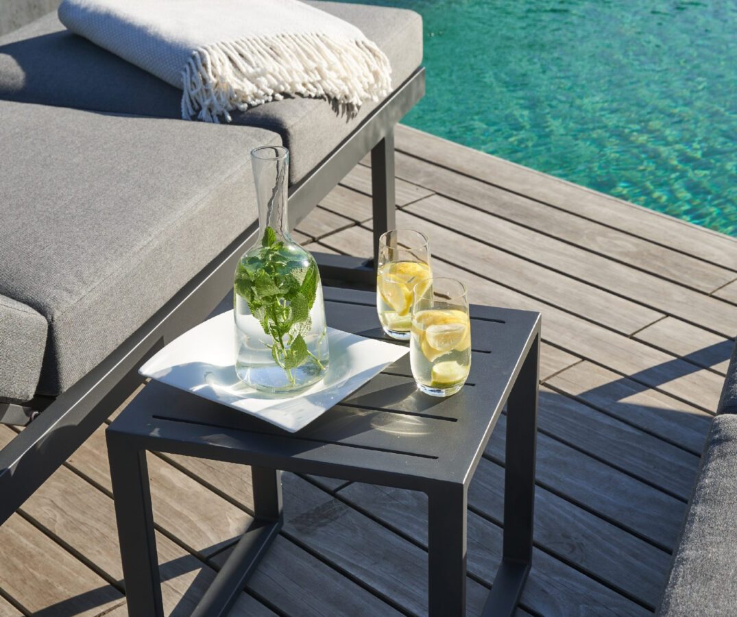 Beistelltisch mit Getränken neben einem Loungesofa