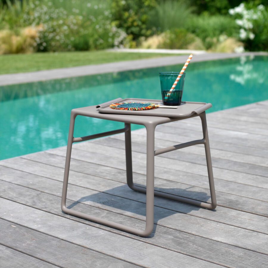 Beistelltisch mit einem Getränk neben dem Pool