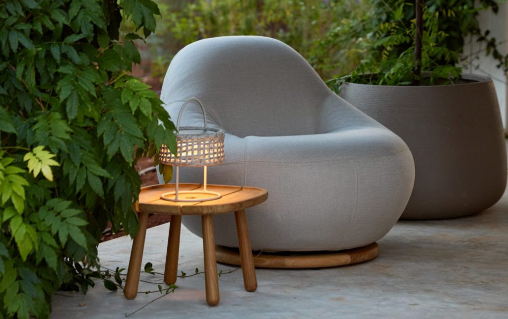 Organischer Loungesessel mit Beistelltisch im Grünen