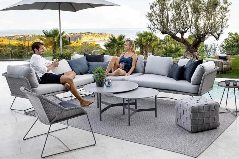 Frau und Mann sitzen auf bequemer Lounge auf farblich passendem Outdoor-Teppich.