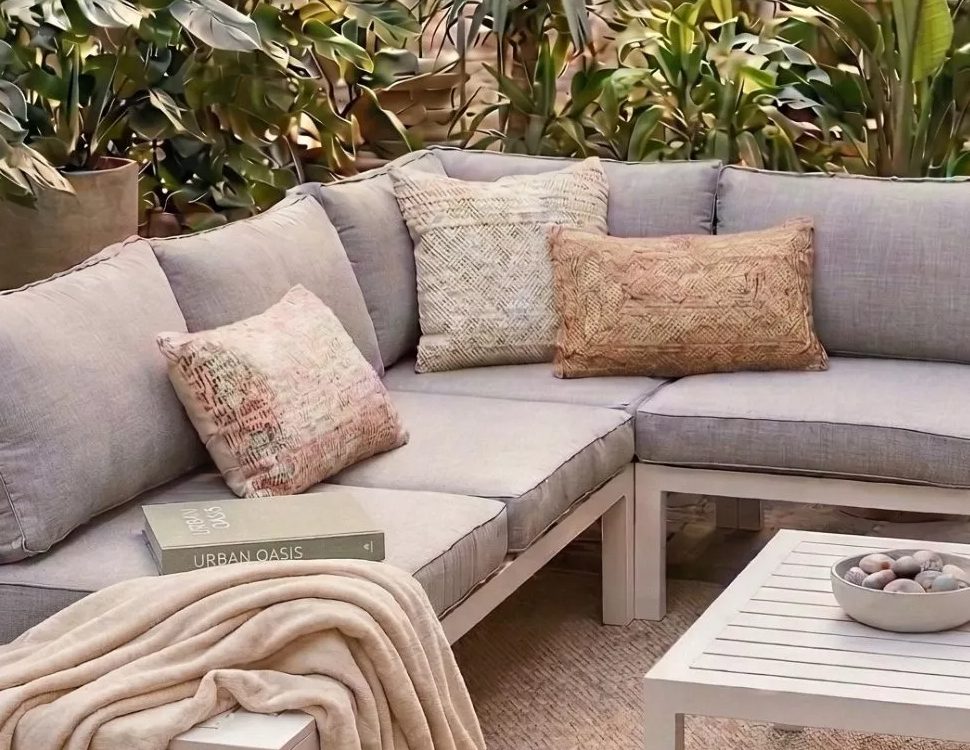 Gepolsterte Lounge mit naturfarbenen Kissen dekoriert