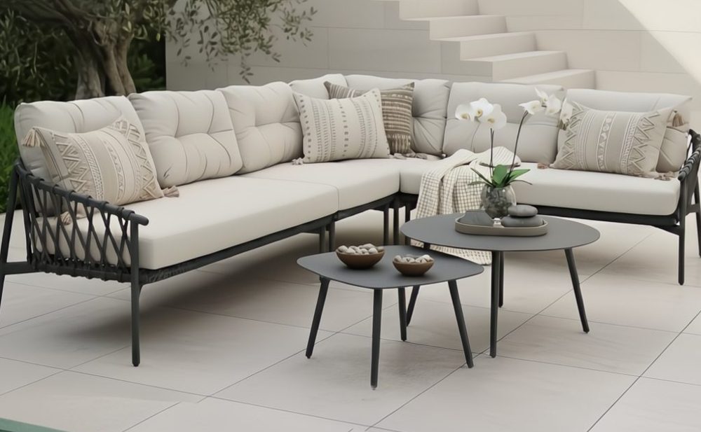 Ecklounge mit Rope und dicken Polstern sowie zwei kleine Beistelltische auf einer minimalistischen Terrasse
