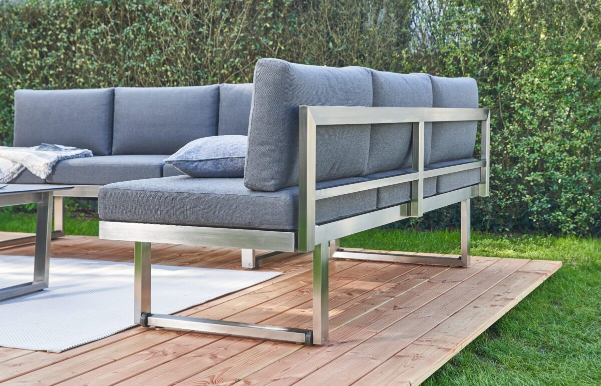 Rückansicht eines Loungesofas auf einer Holzplattform im Garten